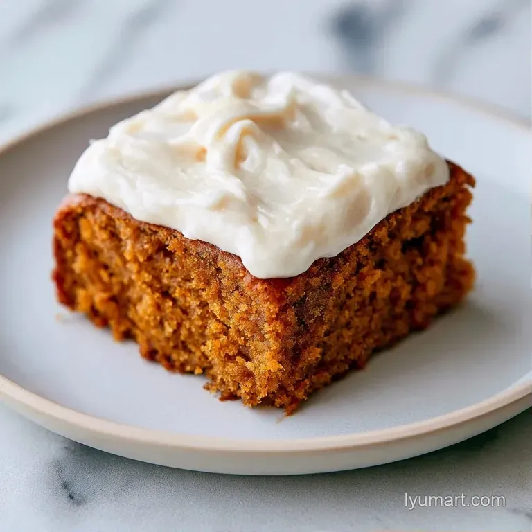 A single orange cake slice on a white ceramic plate, topped with a smooth cream swirl and a dusting of cinnamon.